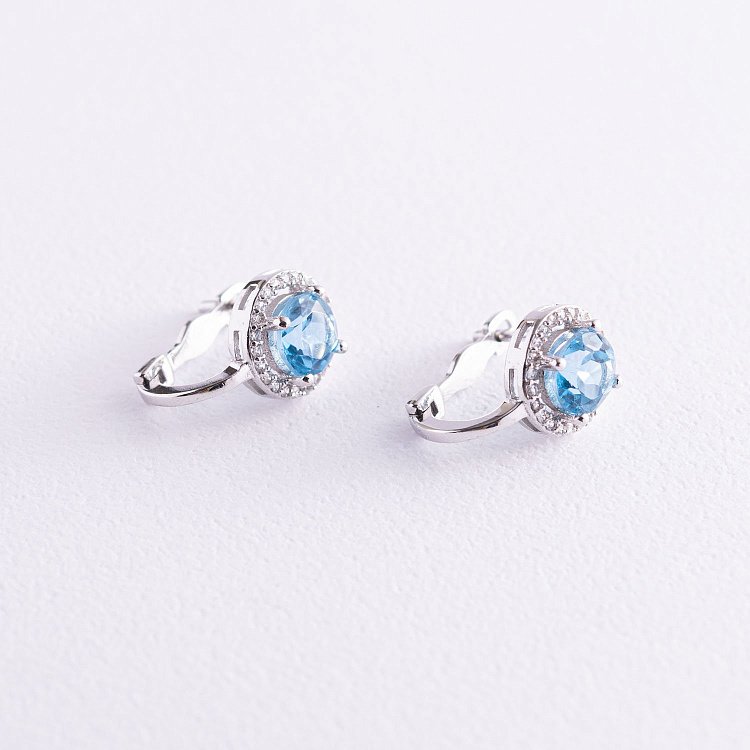 Золоті сережки з блакитними топазами і фіанітами с04167 від ювелірного магазину Онікс