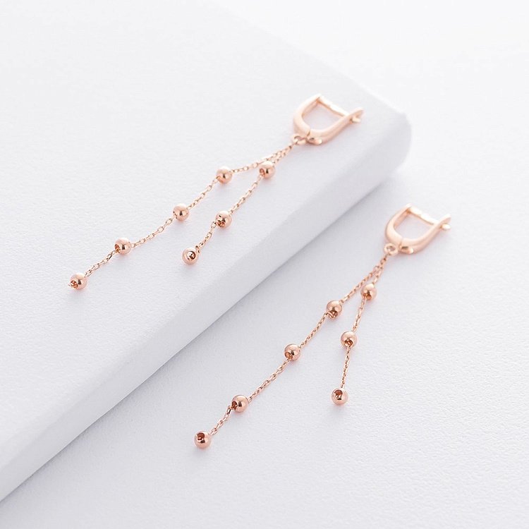 Золоті сережки на ланцюжку з кульками с07770 від ювелірного магазину Онікс